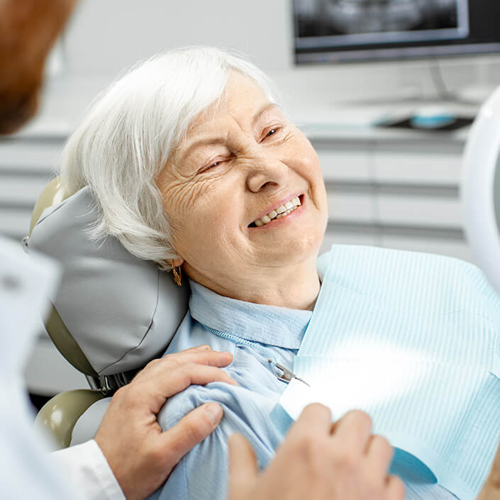smiling senior woman sitting in a dental chair