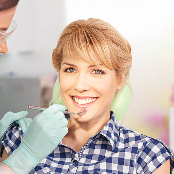 woman having her teeth cleaned with special dental tools