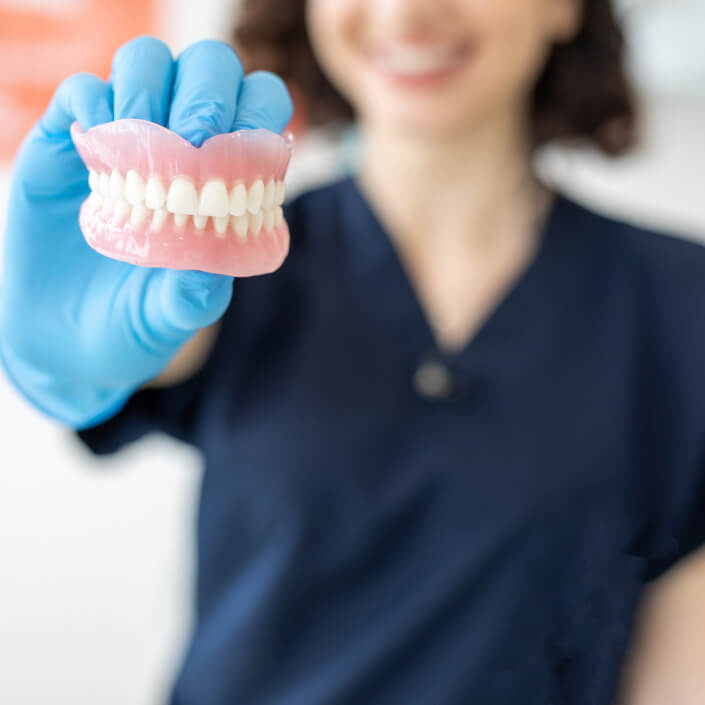 woman holding dentures