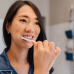 woman brushing her teeth to prevent enamel erosion and wear