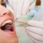 young woman getting oral cancer screening at the dentist