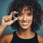 woman invisalign candidate holding clear aligner